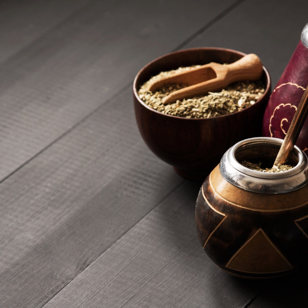 Mate gourd with bombilla and yerba in a bowl with serving spoon